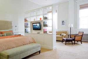纽波特The Vanderbilt, Auberge Resorts Collection的一间卧室配有一张床、一台电视和一张书桌