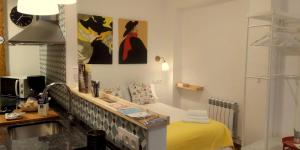 洛格罗尼奥Casa Eladia的客房设有一张黄色的床和一张书桌,并装饰有一些绘画作品。