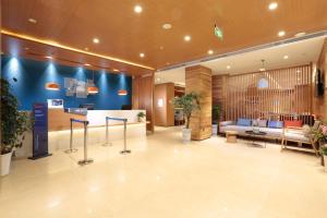 九寨沟Holiday Inn Express Jiuzhaigou,Only 600 Meters to Jiuzhaigou Park, an IHG Hotel的大堂设有带沙发和桌子的等候室