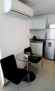 布卡拉曼加AMOBLADOS MCCORMICK的厨房配有桌子、两把椅子和冰箱