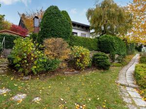 LangscheidHoliday home in Langscheid with panoramic view的灌木丛和房屋的花园