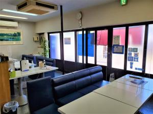 直岛町雅多七海滩酒店的一间设有桌椅和窗户的等候室