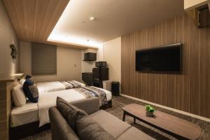 鹿儿岛GRAND BASE Kagoshima Tenmonkan的酒店客房设有两张床和一台平面电视。