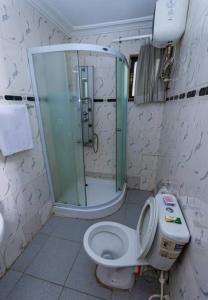 伊凯贾Choice Suites III的带淋浴、卫生间和盥洗盆的浴室