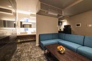 鹿儿岛GRAND BASE Kagoshima Tenmonkan的客厅配有蓝色的沙发和桌子