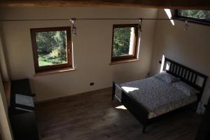 查维然诺Residenza di Campagna的一间卧室设有一张床和两个窗户。
