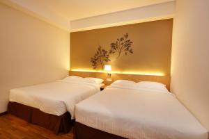 吉隆坡中谷六季酒店 的配有白色床单的客房内的两张床