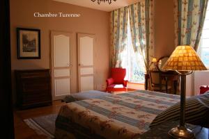 多尔多尼河畔博利厄格勒泽城堡酒店的一间卧室配有一张床、一盏灯和一把椅子