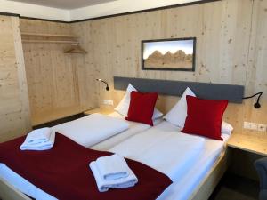 拉姆绍达赫斯坦Berghotel Türlwand的一间卧室配有两张带红白色枕头的床