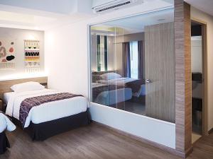 清迈Darley Hotel Chiangmai的酒店客房设有一张床和一面大镜子
