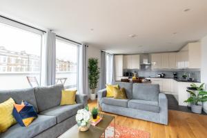 伦敦homely – Central London Luxury Apartments Camden的一间带两张沙发的客厅和一间厨房
