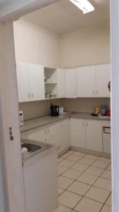 开普敦MJ ACCOMODATION的厨房配有白色橱柜和水槽