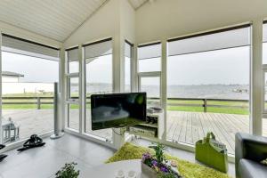 蒙克博Eksklusiv sommerhus beliggende i vandkanten的带电视的客厅,享有海景。