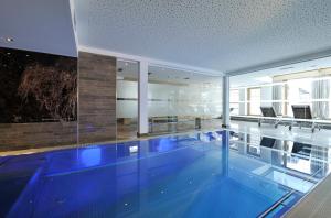玛丽亚阿尔姆日落 - 福迪舍公寓式酒店的蓝色建筑中的游泳池