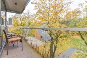 帕兰加Palanga Apartments Near Baltic Sea的阳台设有长凳,享有树林美景。