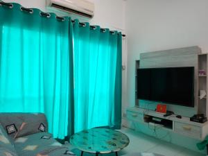 普崇Lake Residence No165 @aesthetic lake view & best photograph的客厅配有绿色窗帘和电视