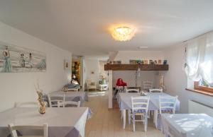 利多迪卡马约雷伊尔福蒂诺别墅住宿加早餐旅馆的一间设有白色桌子和白色椅子的餐厅,以及一间供个人用餐的餐厅