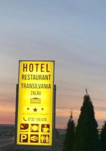 札勒乌Hotel Transilvania Zalău的饭店餐厅黄色标志的变色灵达玛