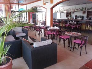 科斯塔特吉塞塔百巴公寓酒店的一间带桌椅的餐厅和一间酒吧