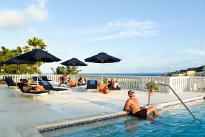 黎明海滩公主高地豪华公寓酒店的坐在度假村游泳池里的男人