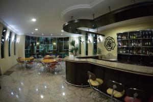 蓬塔格罗萨巴布广场酒店的餐厅设有酒吧,配有桌椅