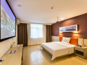 苏州7天酒店·苏州狮山龙湖天街店的配有一张床和一台平面电视的酒店客房