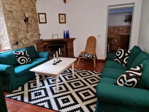 阿尔赫西拉斯康布里乡间赫塔格朗德酒店的客厅配有绿色沙发和咖啡桌