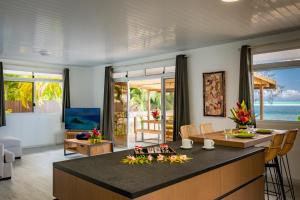 波拉波拉Matira Sandy Home 658 DTO-MT的厨房以及带桌椅的起居室。