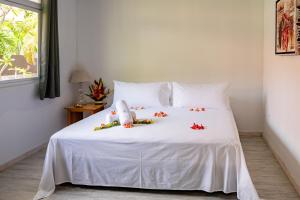波拉波拉Matira Sandy Home 658 DTO-MT的卧室配有带鲜花的白色床