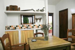 Cuevas del Becerro科尔蒂霍新阿罗加门托乡村公寓的一间带桌子的用餐室和一间厨房