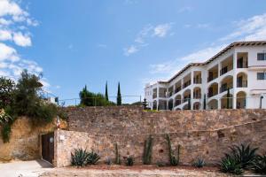 贝纳尔Hotel Quinta Las Fuentes Bernal的仙人掌石墙后面的建筑