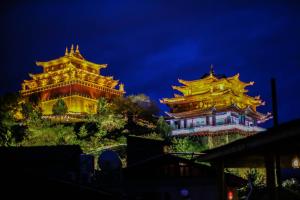 香格里拉阿若康巴南索达庄园 的夜晚山上的两座中国建筑