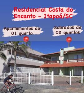 伊塔波阿Costa do Encanto unidade Itapoa的一个人在建筑物前骑着自行车