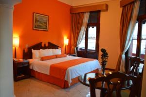 危地马拉皇宫酒店的一间卧室配有一张橙色墙壁的床