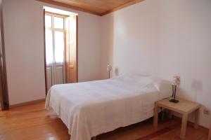 曼泰加什Casa das Tias的白色卧室配有床和桌子
