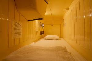 东京汤岛胶囊旅馆（只限男性）的一个小走廊,房间内设有一张床