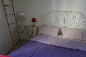 布林迪西L'atmosfera的一间卧室配有一张带白色床头板的紫色床