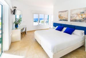 埃尔戈尔福艾尔迪尔戈尔福海酒店的白色和蓝色的卧室配有一张床和一张书桌