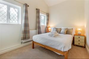 BredonGuest Homes - The Old Thatch的一间卧室设有一张床和一个窗口