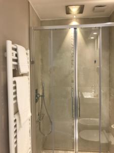 里乔内Hotel Villa Hermosa的浴室里设有玻璃门淋浴