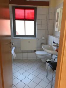路德斯塔德·威特比Ferienwohnungen am Schloss的一间带水槽和卫生间的浴室以及窗户。