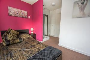 布莱顿霍夫Brighton Townhouse - Central- by Brighton Holiday Lets的卧室设有粉红色的墙壁和一张床