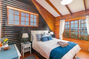 克尼斯纳Big Tree House Lodge的卧室配有一张床铺,位于带木墙的房间内
