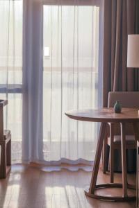 抚松县望·长白鲁能美憬阁精选酒店的客房设有桌子和大窗户。