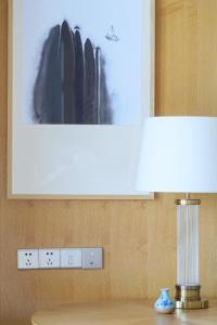 抚松县望·长白鲁能美憬阁精选酒店的一张桌子,上面有台灯和一张墙上的照片