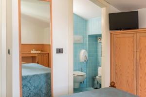 桑格罗堡依尔凯花园德尔里奥酒店的一间带卫生间的浴室和墙上的电视