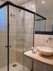 布希奥斯Porto Mar de Búzios的一间带玻璃淋浴和水槽的浴室