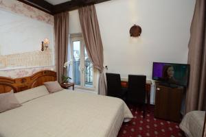 巴黎福美来酒店的配有一张床和一台平面电视的酒店客房