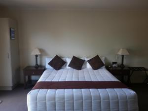 罗托鲁瓦芬顿行政酒店的卧室配有带枕头的大型白色床