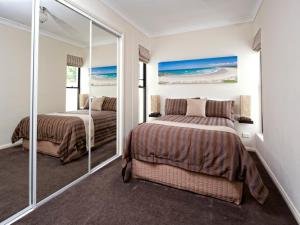 文森提亚海豚海岸酒店的一间卧室配有两张床和镜子